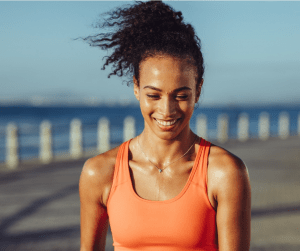 Lipo Smart Beautiful girl running near the ocean sweating and smiling