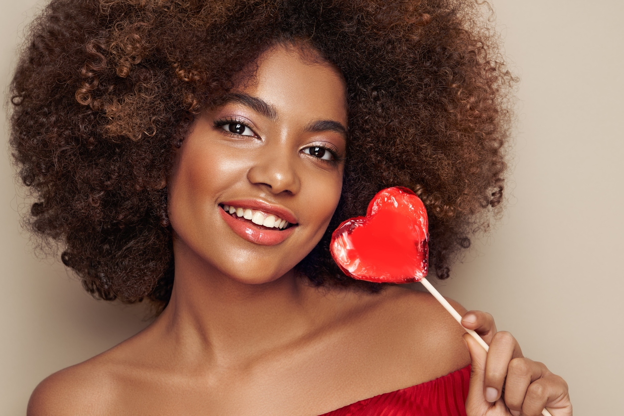 Beautiful woman golding some love heart candy. Love Your Skin at Vedas medical Spa & Wellness Center