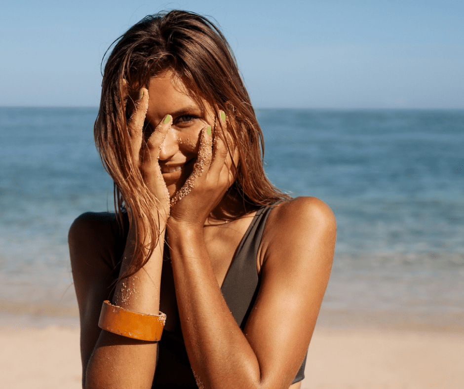Gorgeous woman on the beach with sun kissed. skin and is smiling - Vedas Medical Spa & Wellness Center