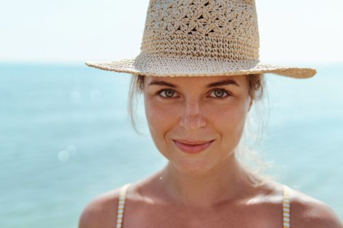 Beautiful woman on the beach. Sun damage repair at Vedas Medical Spa & Wellness Center